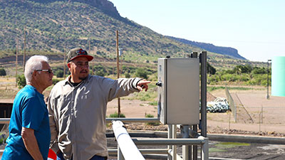 Bayard Mayor Chon Fierro (left) and Stephen Estrada, Laborer/Operator, at the wastewater treatment plant in Hurley, look out over the facility.